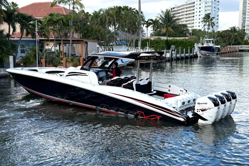 Fire Sale Yacht Photos Pics 2019 MTI V42 boat with multiple engines cruising in a scenic waterfront area.