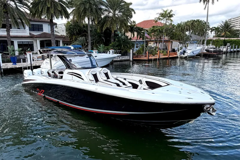 Fire Sale Yacht Photos Pics 2019 MTI V42 boat docked in a scenic waterfront setting with palm trees.