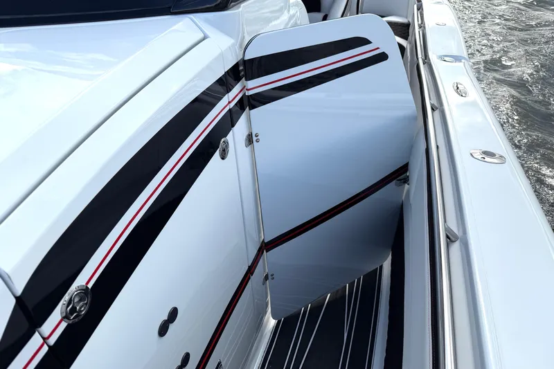 Fire Sale Yacht Photos Pics 2019 MTI V42 boat with open side door, featuring sleek black and red stripes.