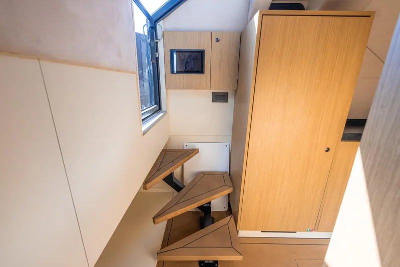  Yacht Photos Pics Modern interior of 2023 Lekker 44 with wooden cabinetry and geometric stairs.