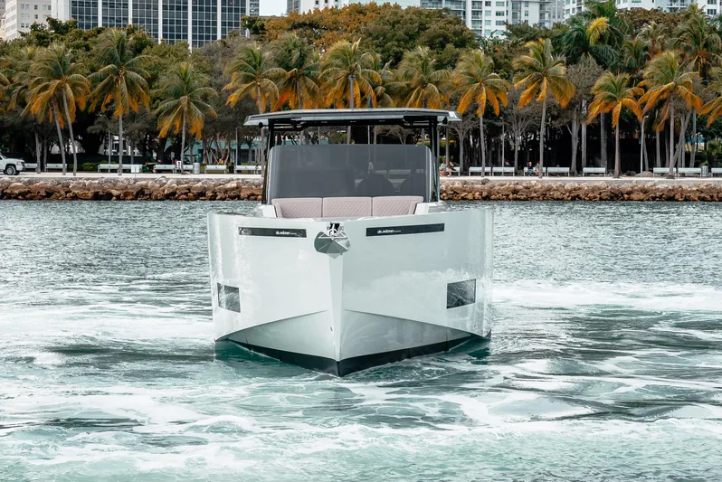  Yacht Photos Pics 2025 De Antonio Yachts D42 Open cruising on water with palm trees in the background.