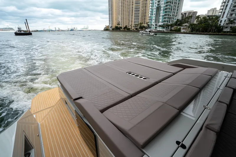  Yacht Photos Pics 2025 De Antonio Yachts D42 Open cruising near city skyline, featuring spacious deck.