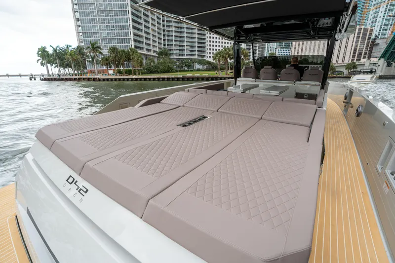  Yacht Photos Pics 2025 De Antonio Yachts D42 Open luxury yacht with spacious sunbathing area, docked by waterfront.