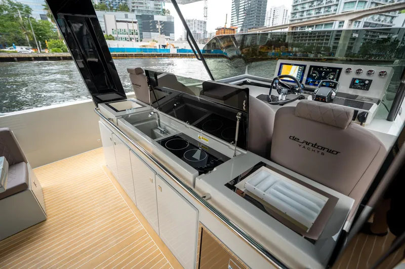  Yacht Photos Pics 2025 De Antonio Yachts D42 Open interior with modern kitchen and helm, cityscape view.