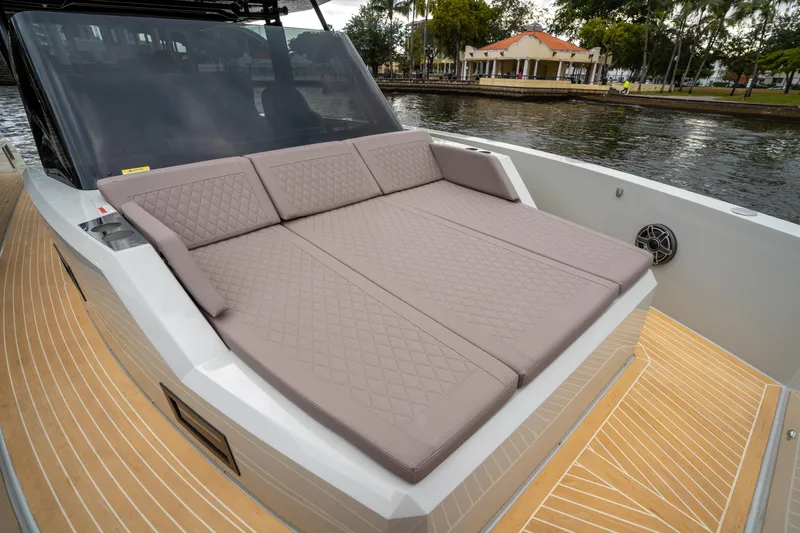  Yacht Photos Pics 2025 De Antonio Yachts D42 Open with spacious sunbed on deck, docked by a waterfront.