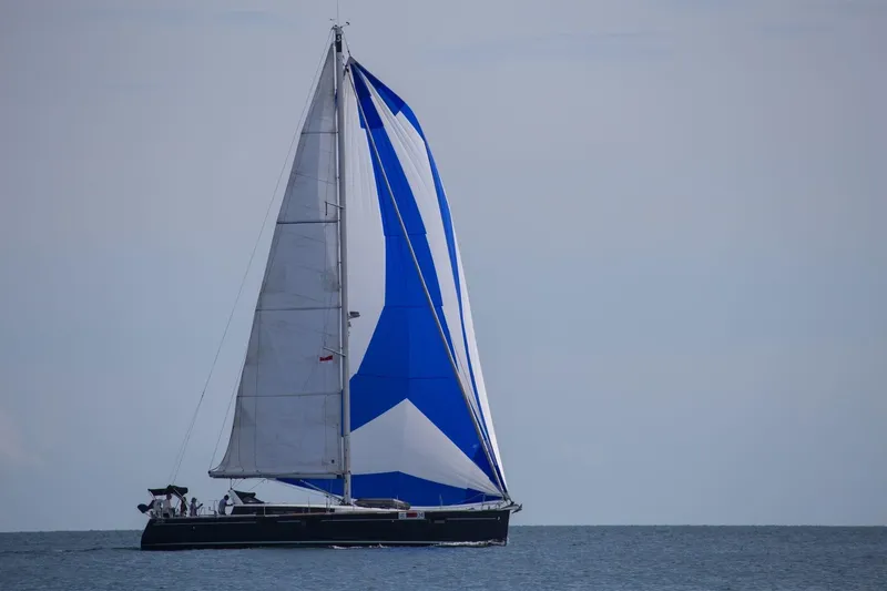  Yacht Photos Pics 2015 Beneteau Sense 55 sailboat with blue and white sails on open water.