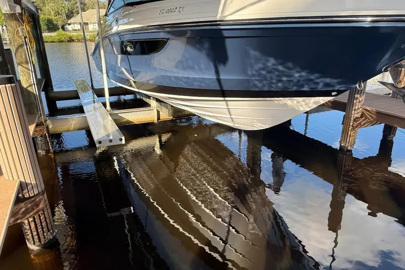 Manda Rae Too Yacht Photos Pics 2018 Sae Ray 38SLV OB boat docked above water, reflecting on calm surface.