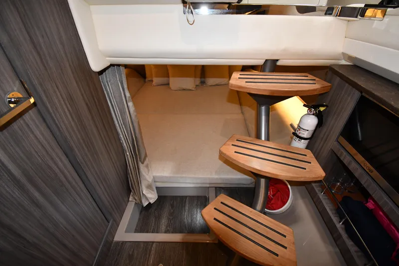  Yacht Photos Pics 2020 Sea Ray SLX 400 Outboard cabin interior with wooden steps and cozy sleeping area.