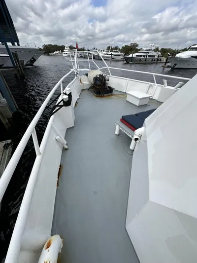 93' Dive Boat Yacht Photos Pics 1965 Custom Dive Boat deck with seating, docked at marina under cloudy skies.