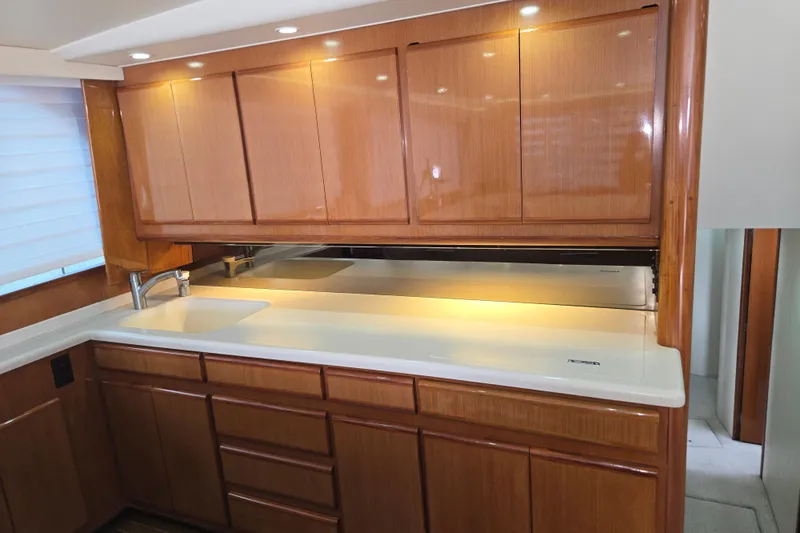Covert Mission Yacht Photos Pics Luxurious kitchen interior of 1998 Viking 58 Convertible yacht with wooden cabinets and modern lighting.