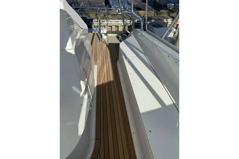 Covert Mission Yacht Photos Pics 1998 Viking 58 Convertible yacht deck with wooden flooring and sleek white railings.