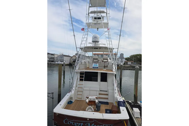 Covert Mission Yacht Photos Pics 1998 Viking 58 Convertible yacht docked at marina, showcasing spacious deck and tower.