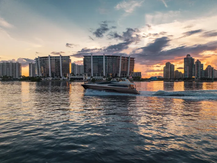  Yacht Photos Pics Luxury Riva 75 Venere yacht cruising at sunset near modern city skyline, 2012 model.