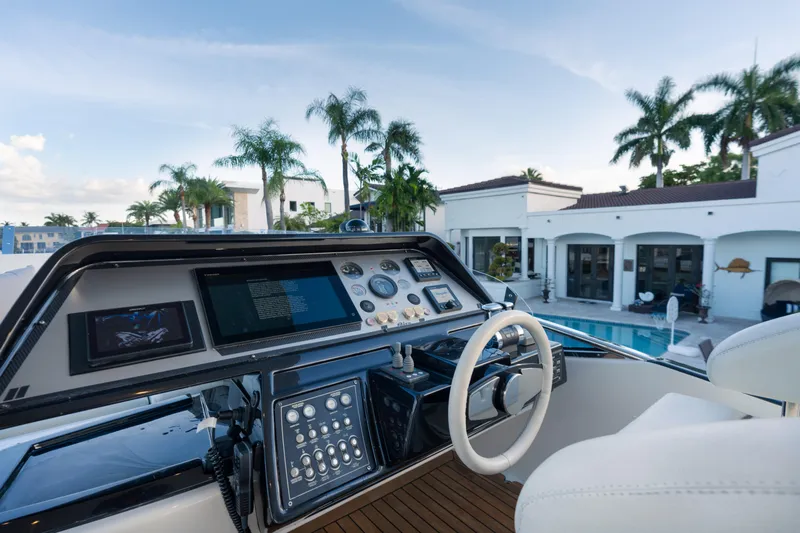  Yacht Photos Pics Cockpit view of 2012 Riva 75 Venere yacht with luxury villa backdrop.