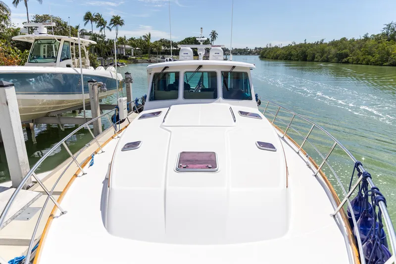  Yacht Photos Pics 2009 Sabre 52 Express yacht docked on a sunny day, surrounded by lush greenery.