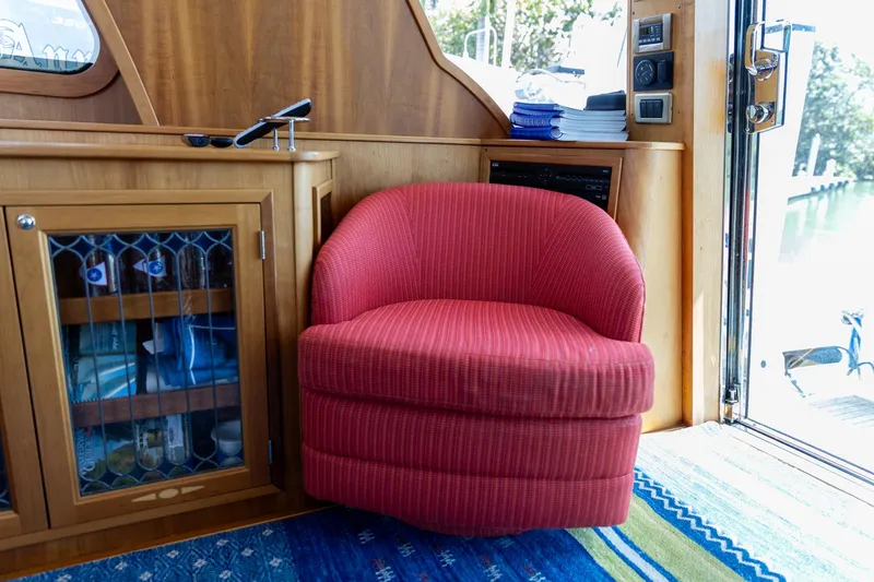  Yacht Photos Pics Red chair in 2009 Sabre 52 Express yacht interior, next to wooden cabinet and glass door.