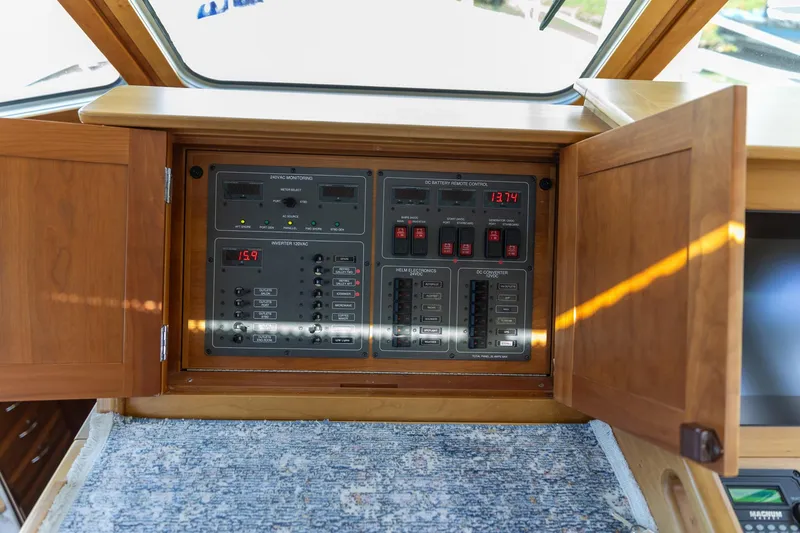  Yacht Photos Pics Electrical control panel on a 2009 Sabre 52 Express yacht, with wooden cabinet doors open.