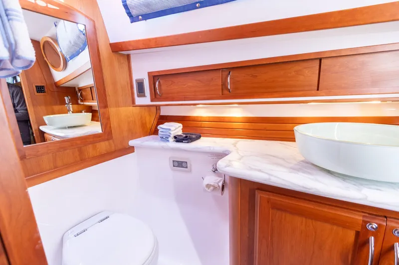  Yacht Photos Pics Luxurious bathroom in 2009 Sabre 52 Express yacht with wooden cabinetry and modern fixtures.