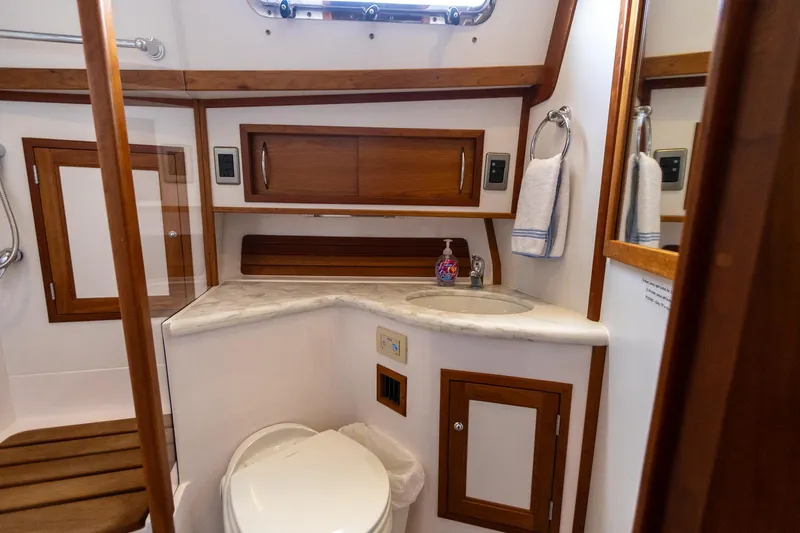  Yacht Photos Pics 2009 Sabre 52 Express yacht bathroom with wooden cabinetry and modern fixtures.