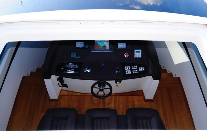 Ea Yacht Photos Pics Cockpit of 2010 Custom Wake 66 boat with navigation equipment and wooden flooring.