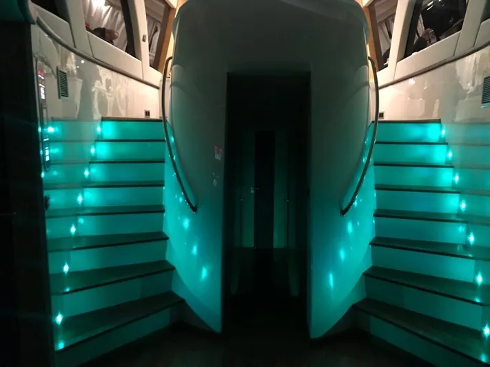 Ea Yacht Photos Pics Illuminated staircase on a 2010 Custom Wake 66 yacht, featuring teal lighting.