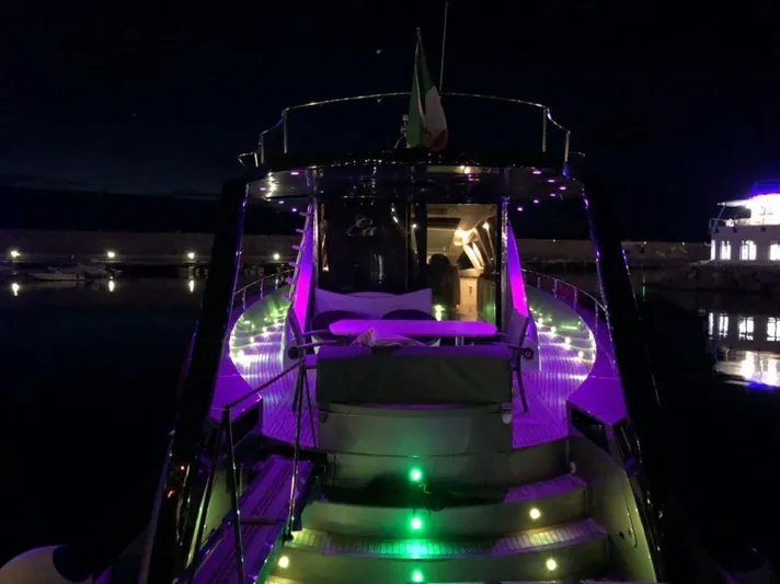 Ea Yacht Photos Pics Luxurious Custom Wake 66 yacht with vibrant purple and green lights at night, 2010 model.