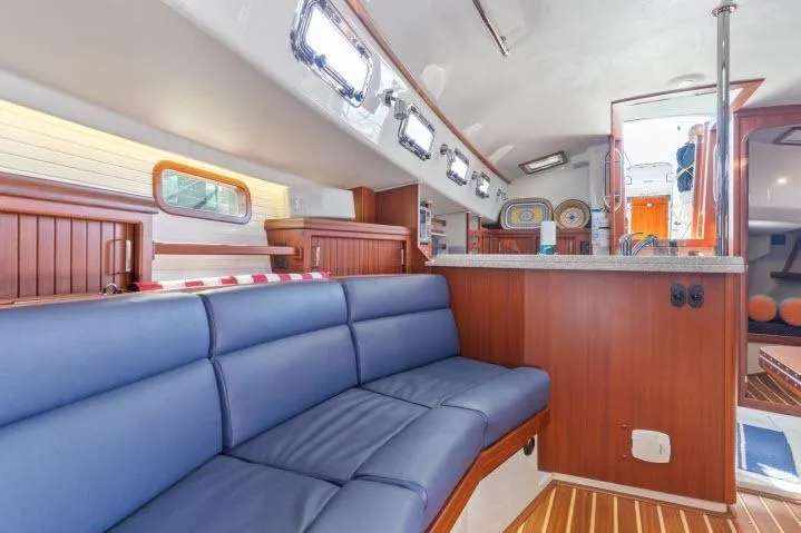 Resolute Yacht Photos Pics Luxurious interior of 2015 Blue Jacket 40 sailboat with blue seating and wooden accents.