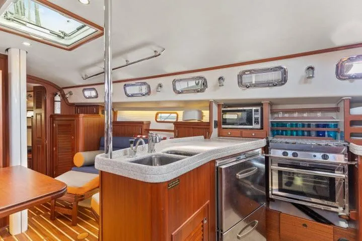 Resolute Yacht Photos Pics Luxurious interior of 2015 Blue Jacket 40 sailboat with modern kitchen and seating area.