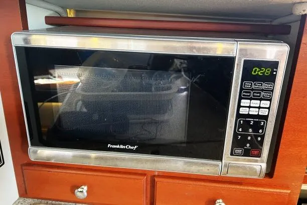 Resolute Yacht Photos Pics Franklin Chef microwave oven in wooden cabinet, digital display showing 0:28.
