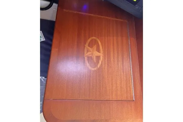 Resolute Yacht Photos Pics Wooden table with star emblem, part of a 2015 Blue Jacket 40 model interior.