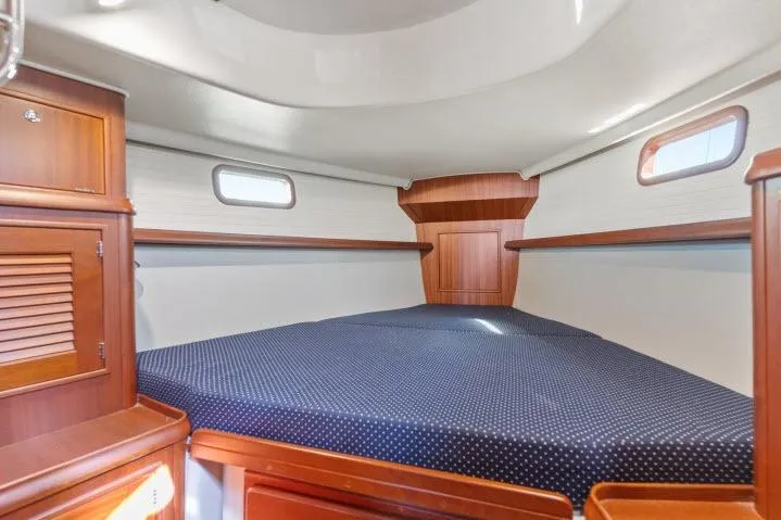 Resolute Yacht Photos Pics Interior cabin of 2015 Blue Jacket 40 sailboat with wooden finish and cozy bedding.