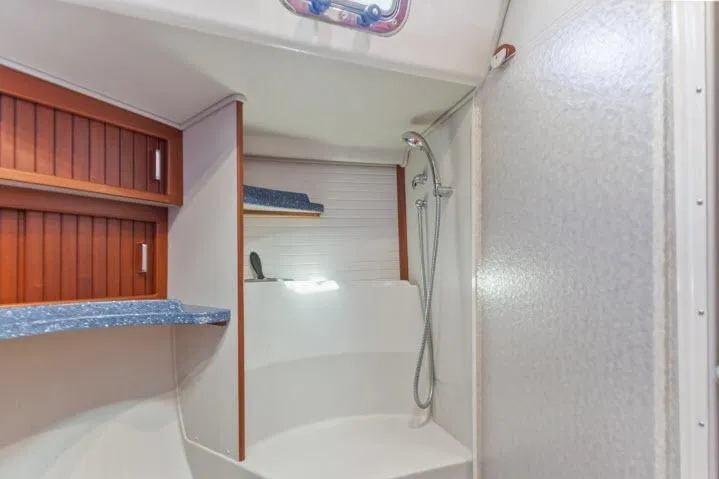 Resolute Yacht Photos Pics Shower area in 2015 Blue Jacket 40 sailboat with wooden cabinets and blue countertops.