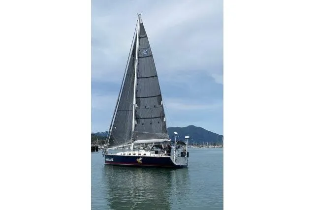 Resolute Yacht Photos Pics Sailboat "Blue Jacket 40" from 2015 on calm water with mountainous backdrop.