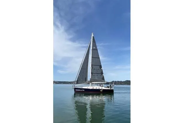 Resolute Yacht Photos Pics Sailboat on calm water, Blue Jacket 40, 2015 model, under clear blue sky.