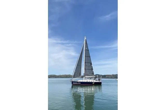 Resolute Yacht Photos Pics Sailboat "Resolute" on calm water, Blue Jacket 40 model, 2015, under clear blue sky.