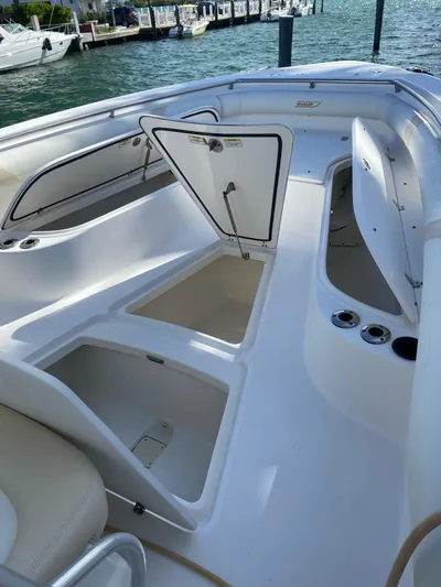  Yacht Photos Pics 2008 Boston Whaler 320 Outrage boat with open storage compartments, docked by the water.