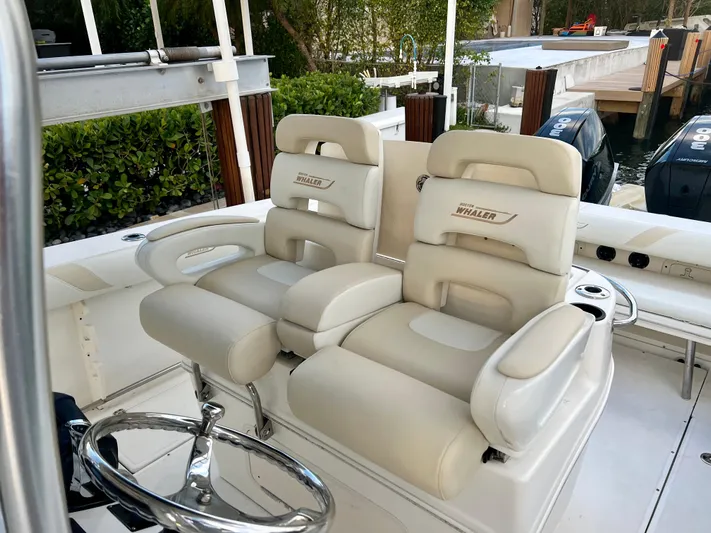  Yacht Photos Pics 2008 Boston Whaler 320 Outrage boat interior with dual cushioned seats and steering wheel.