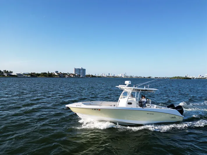  Yacht Photos Pics 2008 Boston Whaler 320 Outrage cruising on a sunny day with city skyline in background.
