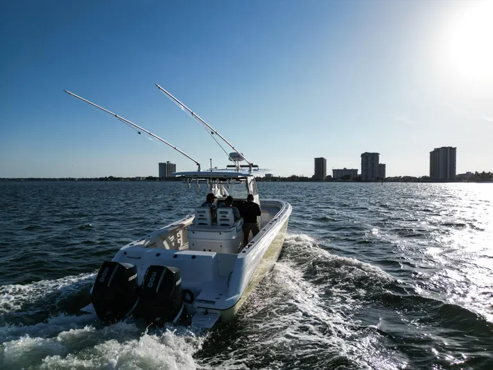  Yacht Photos Pics 2008 Boston Whaler 320 Outrage cruising on open water with city skyline in background.
