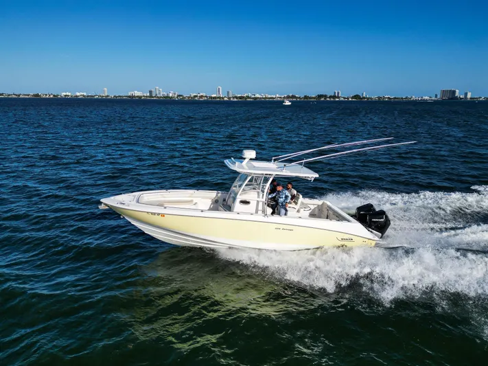  Yacht Photos Pics 2008 Boston Whaler 320 Outrage cruising on open water under clear blue skies.