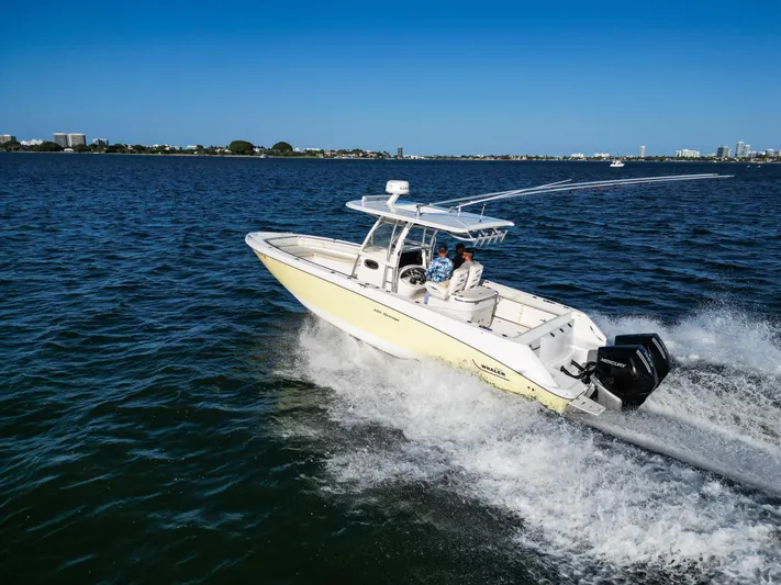  Yacht Photos Pics 2008 Boston Whaler 320 Outrage cruising on open water under clear blue skies.