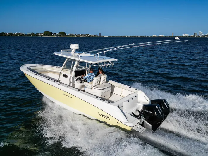  Yacht Photos Pics 2008 Boston Whaler 320 Outrage cruising on open water, showcasing powerful twin engines.
