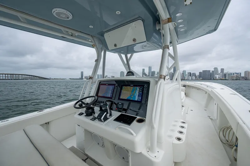  Yacht Photos Pics 2013 Yellowfin 39 Offshore boat interior with navigation system, city skyline in background.