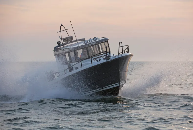 Yacht Photos Pics 2024 Sargo 28 boat cruising through waves at sunset.