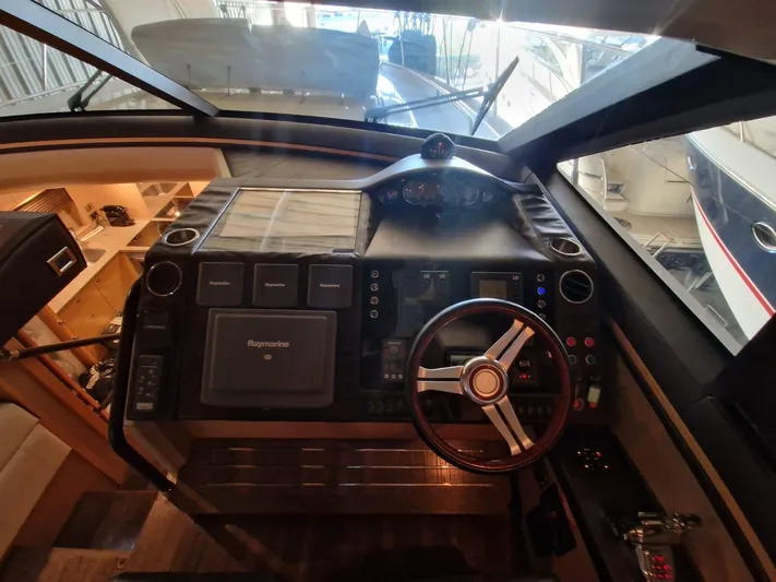  Yacht Photos Pics Cockpit of 2010 Princess V62 yacht with steering wheel and navigation controls.