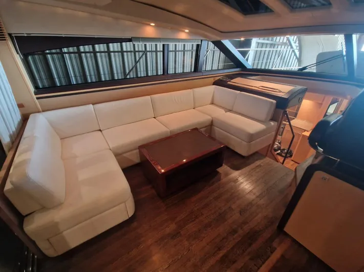  Yacht Photos Pics Luxurious interior of 2010 Princess V62 yacht with white seating and wooden table.