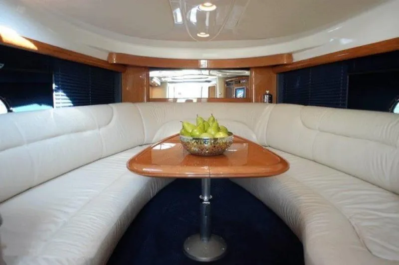  Yacht Photos Pics Interior of 2003 Cranchi Endurance 39 yacht with white seating and wooden table.