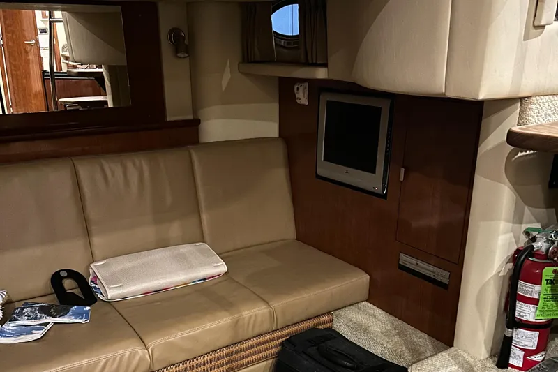  Yacht Photos Pics Interior of 2005 Sea Ray 390 Sundancer with beige seating, TV, and fire extinguisher.