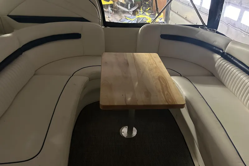  Yacht Photos Pics Interior of 2005 Sea Ray 390 Sundancer with white seating and wooden table.