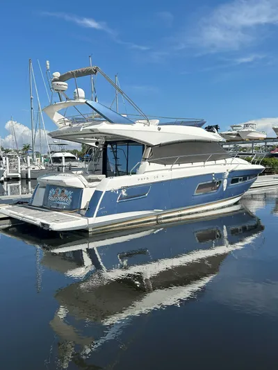  Yacht Photos Pics 2015 Prestige 450 Fly yacht docked, reflecting on calm water under a clear blue sky.